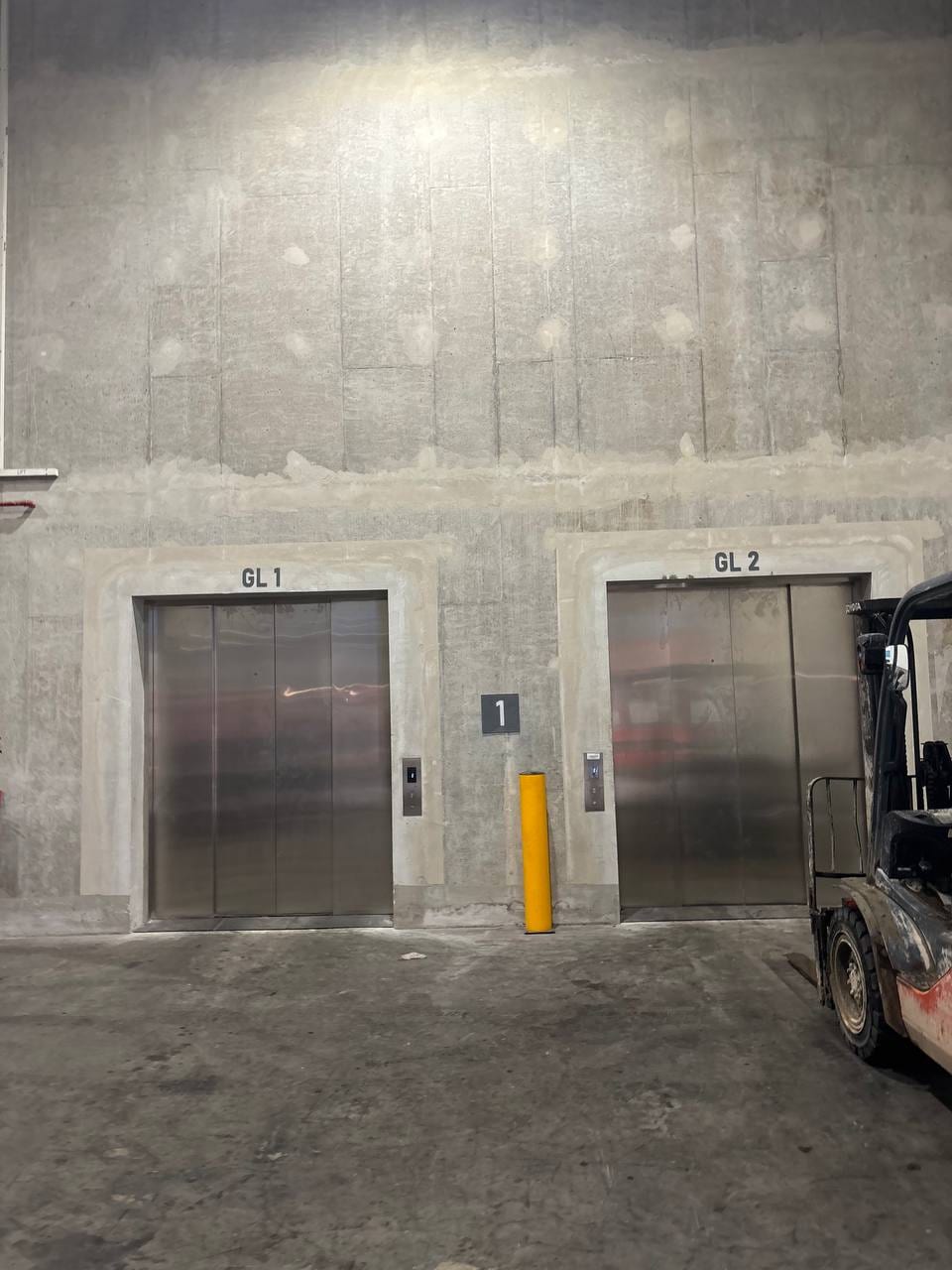 Cargo lift lobby with a forklift parked beside the doors